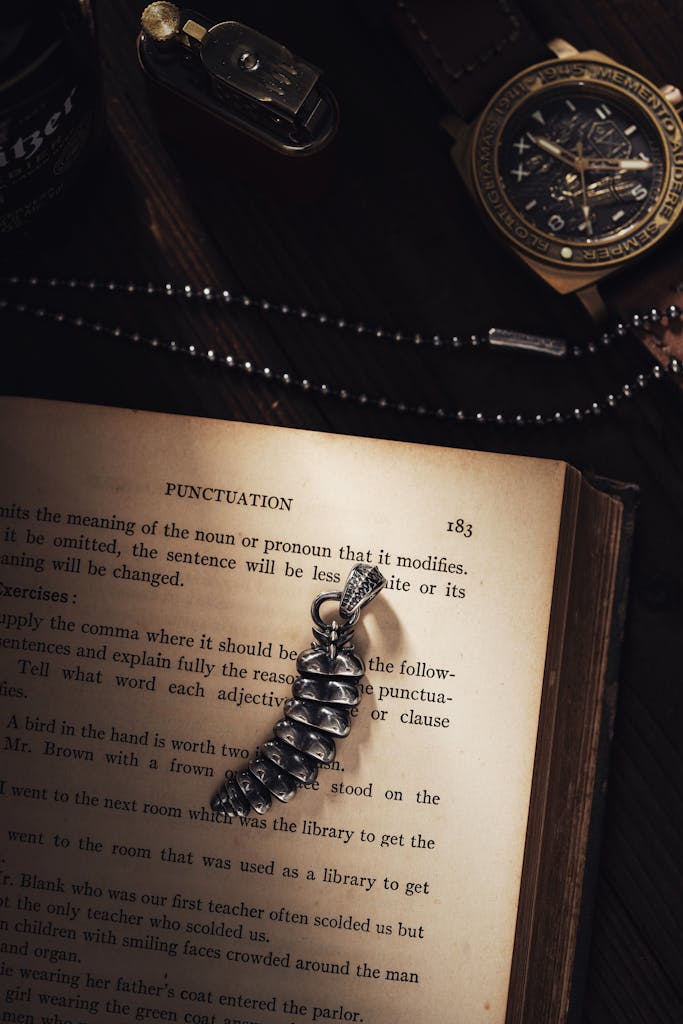 2026년 패션 트렌드 완벽 분석: 당신이 주목해야 할 5가지 변화 7 A timeless arrangement featuring a book, jewelry, and a stylish watch on a wooden desk.