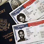 Close-up of a U.S. passport with visas and currency, symbolizing international travel and immigration.